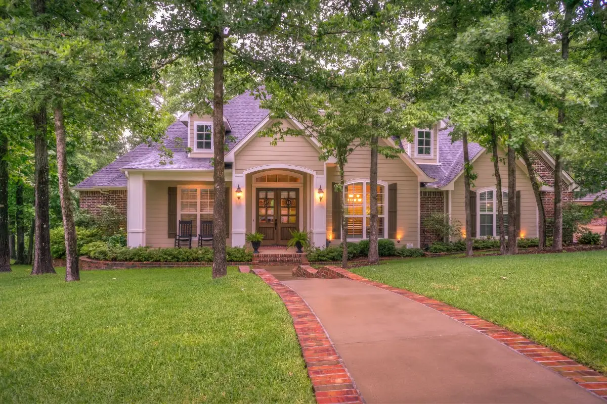 A charming, single-story house with a brick path and surrounded by lush trees and a well-kept lawn, this property offers potential for seamless Airbnb management or cohosting services.